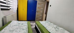 a small room with a bed and a colorful door at VITAN Central Apartament in Tîrnăveni