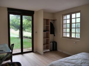 a bedroom with a bed and a window and a table at Domaine la Pause in Aveyron in Vabres-lʼAbbaye
