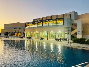 ein Gebäude mit einem Swimmingpool vor einem Gebäude in der Unterkunft Furnished Villa in Andalusian Compound for Rent in Madaba