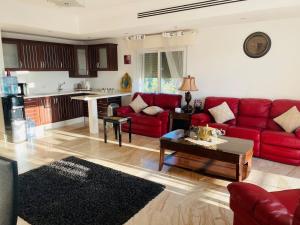 ein Wohnzimmer mit roten Sofas und eine Küche in der Unterkunft Furnished Villa in Andalusian Compound for Rent in Madaba