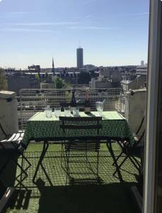 a table on a balcony with a view of a city at 2 bedrooms in the sky ! in Neuilly-sur-Seine