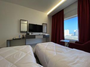 una habitación de hotel con una cama y una ventana grande en Al Falak Hotel فندق الفلك, en Ma‘ābīlah