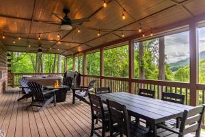 a screened porch with a ping pong table and chairs at Buck Ridge in West Jefferson
