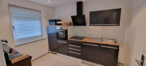 a small kitchen with a sink and a tv at Ferienwohnung Lösel in Freilassing