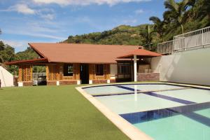 a house with a swimming pool in front of a house at Hotel Campestre VillaMaria in Vergara