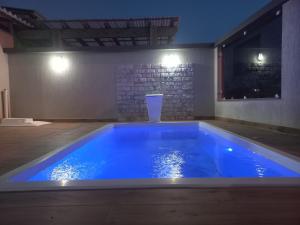 ein großer blauer Pool in einem Zimmer in der Nacht in der Unterkunft Casa Com Piscina Pertinho Do Mar Em Capão Da Canoa in Capão da Canoa + 111 Fotos