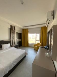 una habitación de hotel con una cama grande y un sofá en Al Falak Hotel فندق الفلك, en Ma‘ābīlah 28 fotos más