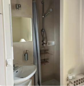 a white bathroom with a sink and a mirror at 2 bedrooms in the sky ! in Neuilly-sur-Seine