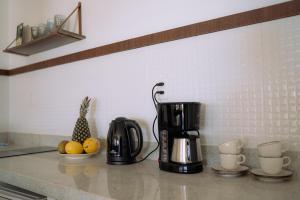Eine Kaffeemaschine und Obst auf der Küchentheke in der Unterkunft Casa Iguana in Trairi