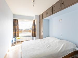 a white bedroom with a large bed and a window at Con Amore - 0403 in Westende Bad