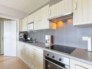 a kitchen with white cabinets and a stove top oven at Con Amore - 0403 in Westende Bad