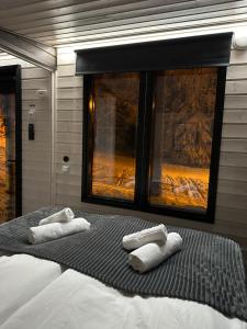 a bedroom with two towels on a bed with a window at Santa Elves Cabin in Rovaniemi