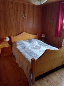 una camera da letto con un letto di legno in una stanza di Chalet des ORCHIDÉES en Chartreuse a Entremont-le-Vieux