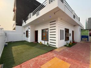 诺伊达ParkHaven Luxury Villa with Garden View的前面有绿色草坪的白色房子