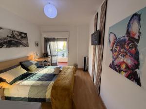 Entroncamento & Fátima في انترونكامنتو: غرفة نوم بها سرير ولوحة لكلب على الحائط