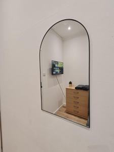 E1 Brick Lane Rooms في لندن: مرآة على جدار مع خزانة في الغرفة