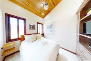 une chambre blanche avec un lit et une télévision dans l'établissement Enjoy Savings Oceanfront Private Estate By Alom, à San Pedro