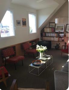 a living room with chairs and a table with flowers at 2 bedrooms in the sky ! in Neuilly-sur-Seine