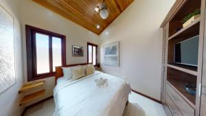 une chambre avec un lit blanc et une télévision dans l'établissement Enjoy Savings Oceanfront Private Estate By Alom, à San Pedro 151 autres photos