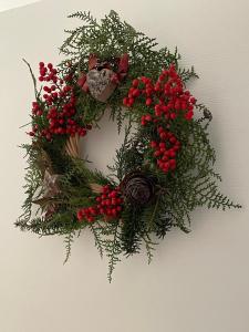 a christmas wreath with red berries on a wall at Cà Marasciol in Villa di Tirano +51 photos