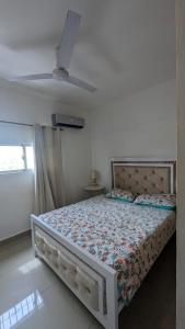 Ce lit se trouve dans une chambre dotée d'un ventilateur de plafond. dans l'établissement Mitaly apartamentos RD H, à Saint-Domingue