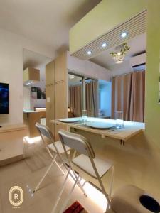 una cucina con tavolo in vetro e 2 sedie di R Cabin - Shore Residences a Manila
