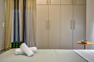 a bedroom with a bed with white cabinets and a chair at Kozimo boutique katoikia in Patra