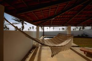eine Hängematte, die an der Seite eines Gebäudes hängt in der Unterkunft Casa Iguana in Trairi