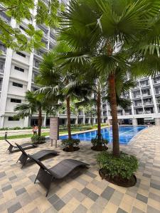 un resort con palme e piscina di R Cabin - Shore Residences a Manila