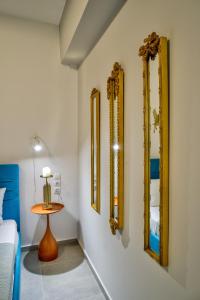 a room with four mirrors and a table and a bed at Kozimo boutique katoikia in Patra