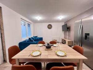 ein Esszimmer mit einem Tisch und einem blauen Sofa in der Unterkunft Maison Moderna-8 personnes-WiFi-Centre ville in Fontenay-le-Comte + 66 Fotos