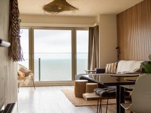 a living room with a couch and a view of the ocean at Nautilus - 0903 in Westende-Bad +3 photos