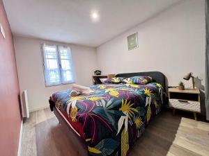 ein Schlafzimmer mit einem Bett mit einer bunten Decke in der Unterkunft Maison Moderna-8 personnes-WiFi-Centre ville in Fontenay-le-Comte
