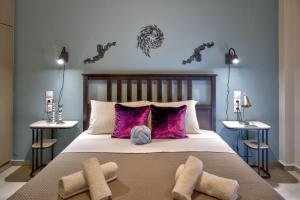 a bedroom with a large bed with purple pillows at Kozimo boutique katoikia in Patra