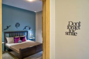 a bedroom with a bed with purple pillows at Kozimo boutique katoikia in Patra