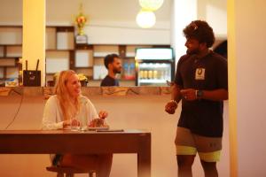 a man standing next to a woman sitting at a table at White Lion Paradise Dikwella in Batigama