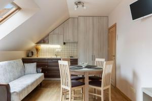 a kitchen and a dining room with a table and chairs at Vila Liepa in Birštonas
