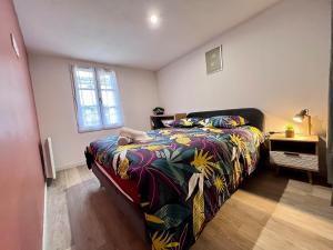 ein Schlafzimmer mit einem Bett mit einer bunten Bettdecke in der Unterkunft Maison Moderna-8 personnes-WiFi-Centre ville in Fontenay-le-Comte