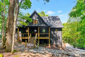 a black house in the woods with trees at Beech Blessings in Beech Mountain