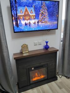 a living room with a fireplace with a tv above it at All4you Chalet Călimănești in Jiblea Veche