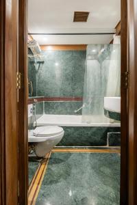 un bagno con un water, un lavandino e una vasca di Hotel Kwality Regency a Chandīgarh