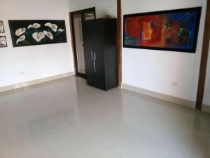 a room with paintings on the wall and a black cabinet at Hostal Brisa y Mar in Arboletes +26 photos