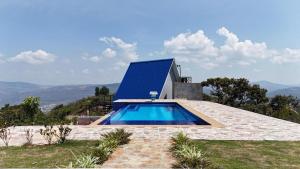 a house with a swimming pool on top of a hill at Cabaña alma del bosque in San Gil +2 photos