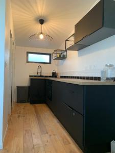 een keuken met zwarte kasten en een houten vloer bij Cabane front de mer in Saint-Brieuc +19 foto's