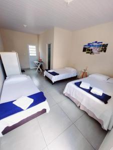 una habitación con 2 camas y una habitación con 2 mesas en Quarto Privativo Cataratas, en Foz do Iguaçu