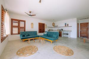 ein Wohnzimmer mit 2 blauen Stühlen und einem Tisch in der Unterkunft Casa Iguana in Trairi