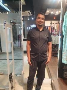 Un hombre parado frente a un espejo en una tienda. en Suite Property Insurance Group Of Company, en Dhaka