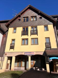 a large yellow building with windows and balconies at Apartmán pod sjezdovkou Lysá Hora Horní náměstí Krkonoše Ski Lumi in Rokytno