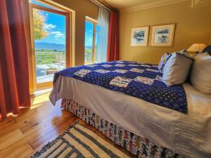 una camera da letto con un letto e una grande finestra di Villa Candle Berry - Tranquil Lagoon Retreat a Brenton-on-Sea