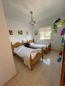 ein Schlafzimmer mit zwei Betten und einem Fenster in der Unterkunft CASA RURAL MALAGA,VILLA FAMARA,10 personas,DESAYUNO ANDALUZ INCLUIDO EN EL PRECIO in Málaga